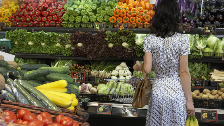 A grocery store shopper looks at produce