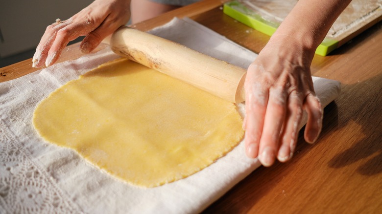 A person rolling out dough