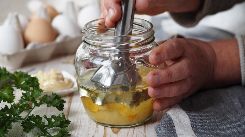 woman making homemade mayo with immersion blender