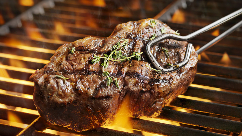 steak with herbs on a grill 