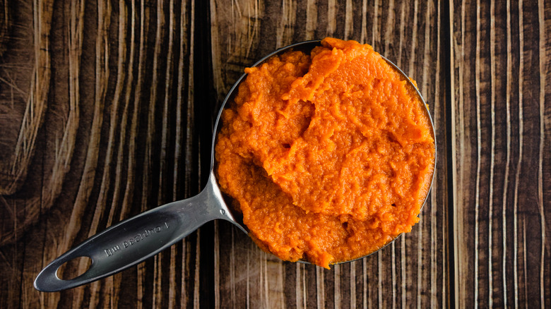 canned pumpkin in measuring cup