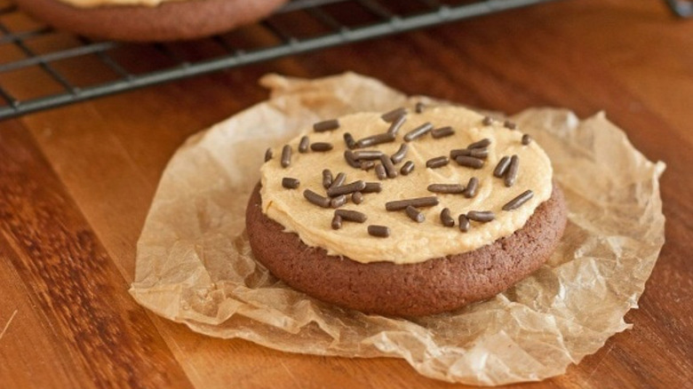 Chocolate cookie with peanut butter frosting and chocolate sprinkles.