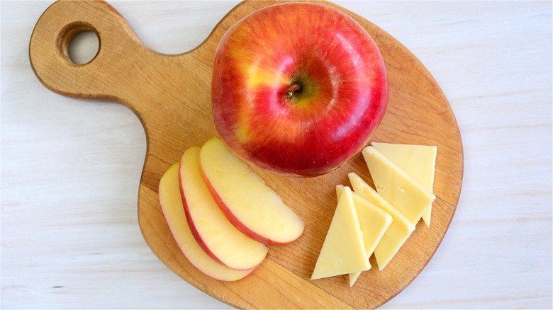 Sliced apple and cheese on board 