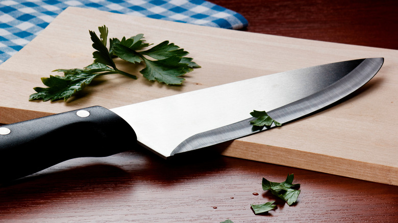 Knife on cutting board with parsley