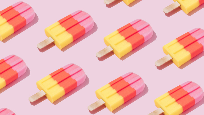 striped popsicles on pink background