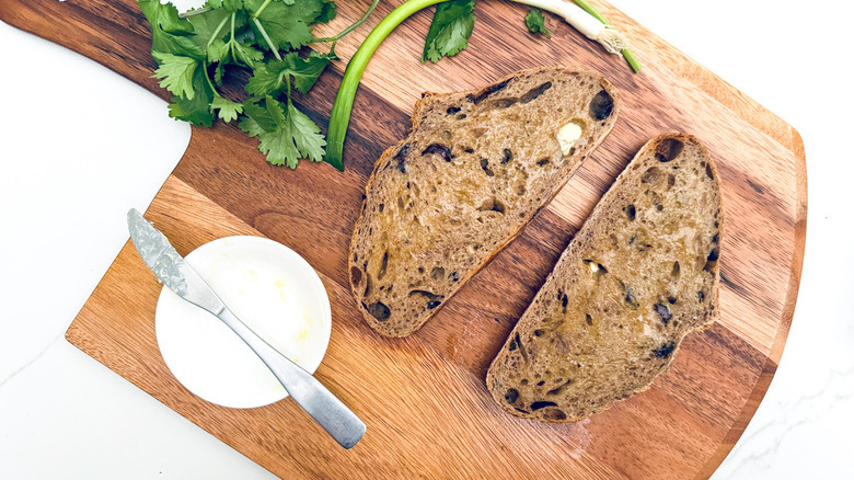 brown bread with butter on cutting board