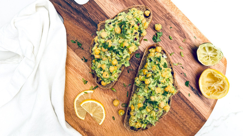 chickpea avocado toast on cutting board with lemon slice